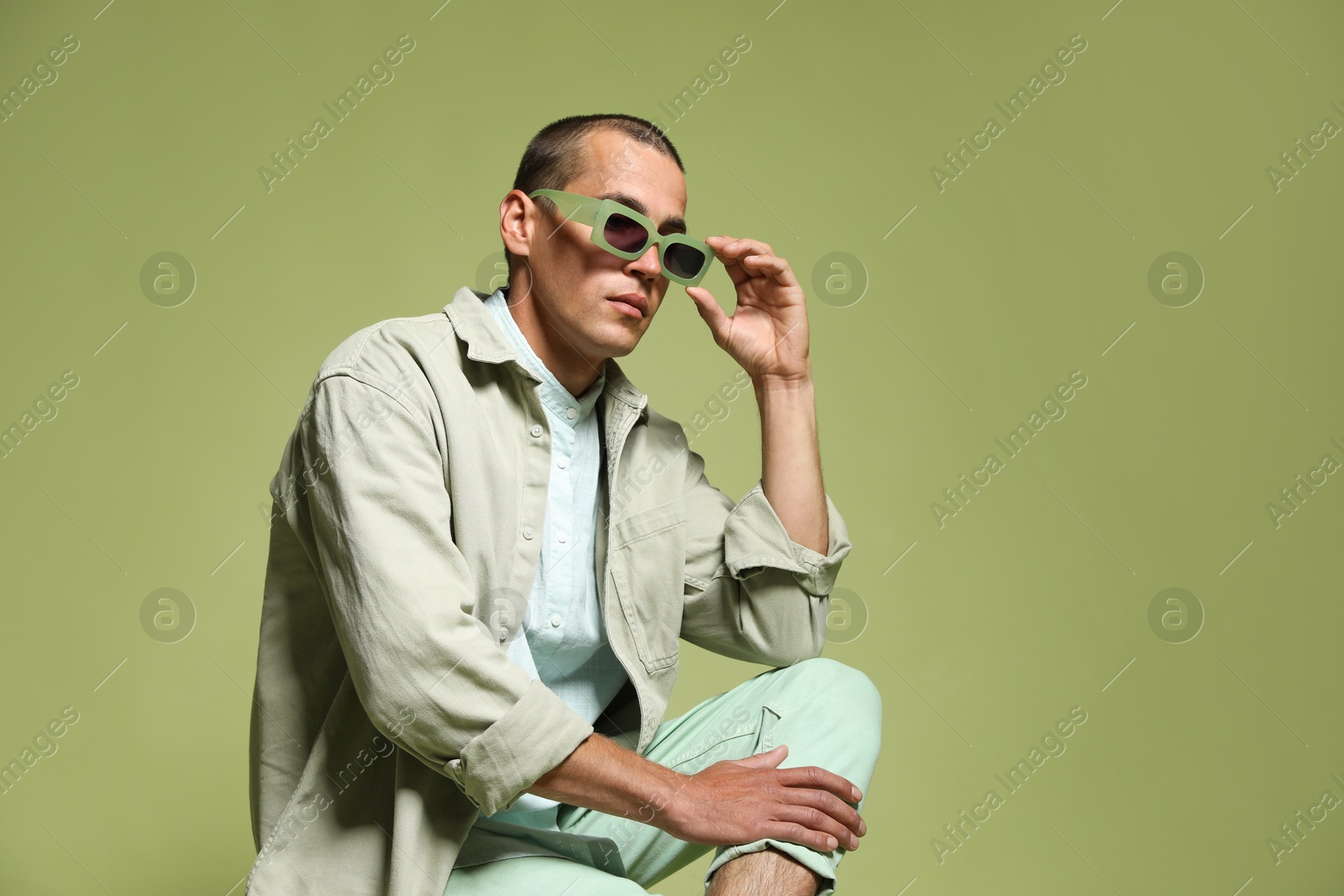 Fashionable portrait of handsome man in stylish outfit on green background, space for text Photo of Fashionable portrait of handsome man in stylish outfit on green background, space for text