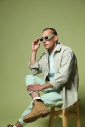 Photo of Fashionable portrait of handsome man in stylish outfit on green background