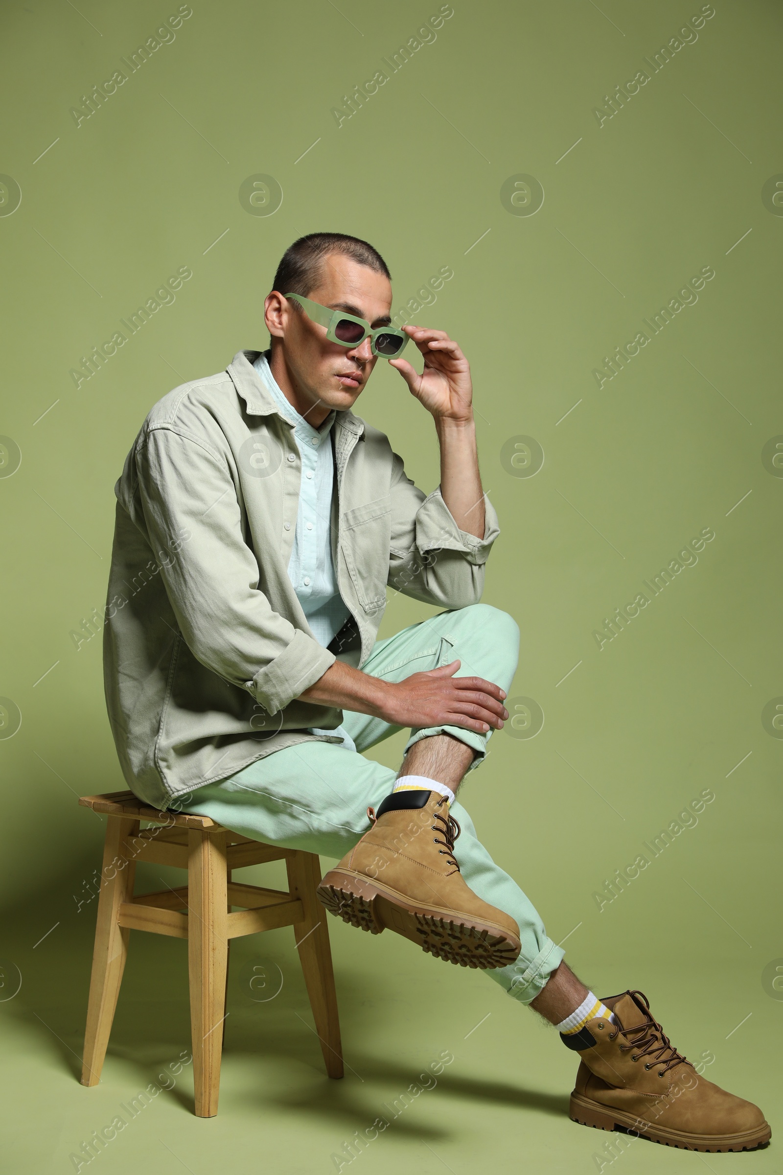 Fashionable portrait of handsome man in stylish outfit on green background Photo of Fashionable portrait of handsome man in stylish outfit on green background