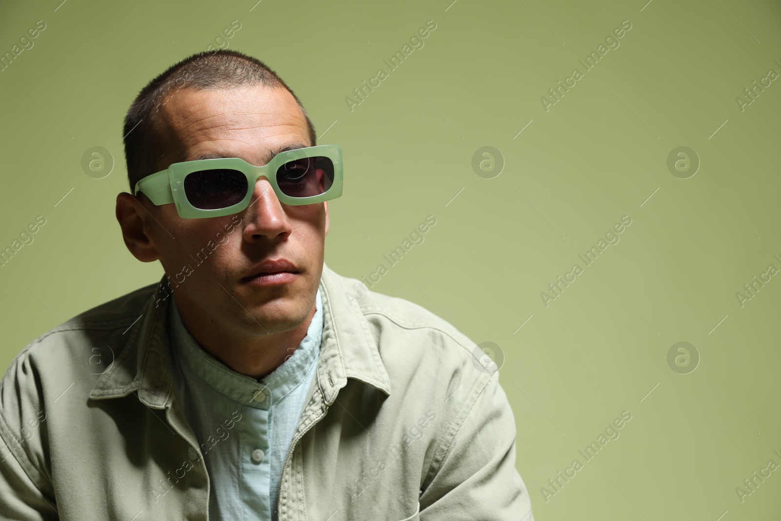 Fashionable portrait of handsome man in stylish outfit on green background, space for text Photo of Fashionable portrait of handsome man in stylish outfit on green background, space for text