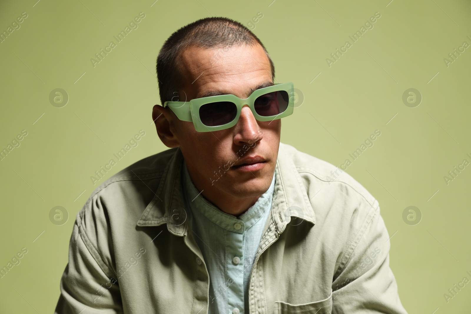 Fashionable portrait of handsome man in stylish outfit on green background Photo of Fashionable portrait of handsome man in stylish outfit on green background