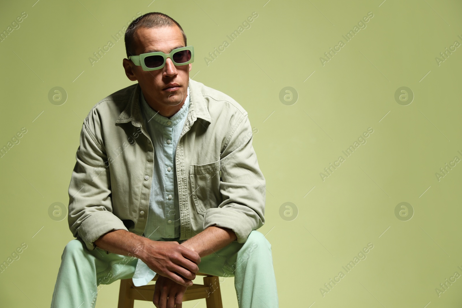 Fashionable portrait of handsome man in stylish outfit on green background, space for text Photo of Fashionable portrait of handsome man in stylish outfit on green background, space for text