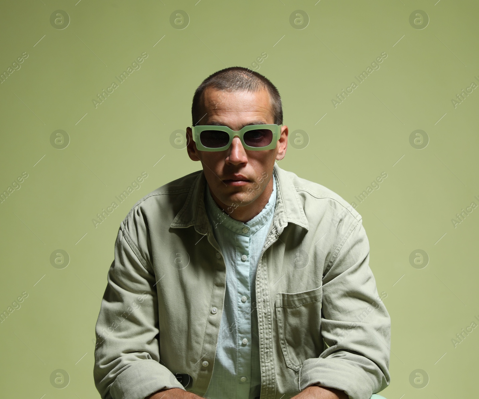 Fashionable portrait of handsome man in stylish outfit on green background Photo of Fashionable portrait of handsome man in stylish outfit on green background
