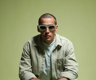 Photo of Fashionable portrait of handsome man in stylish outfit on green background