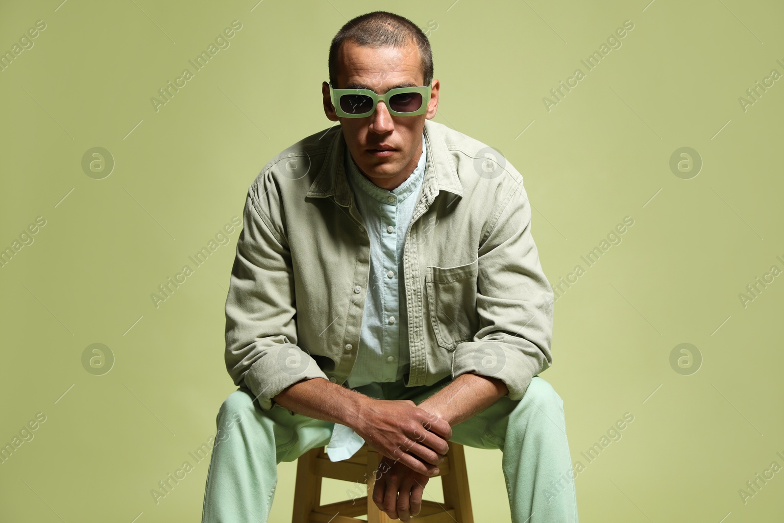 Fashionable portrait of handsome man in stylish outfit on green background Photo of Fashionable portrait of handsome man in stylish outfit on green background