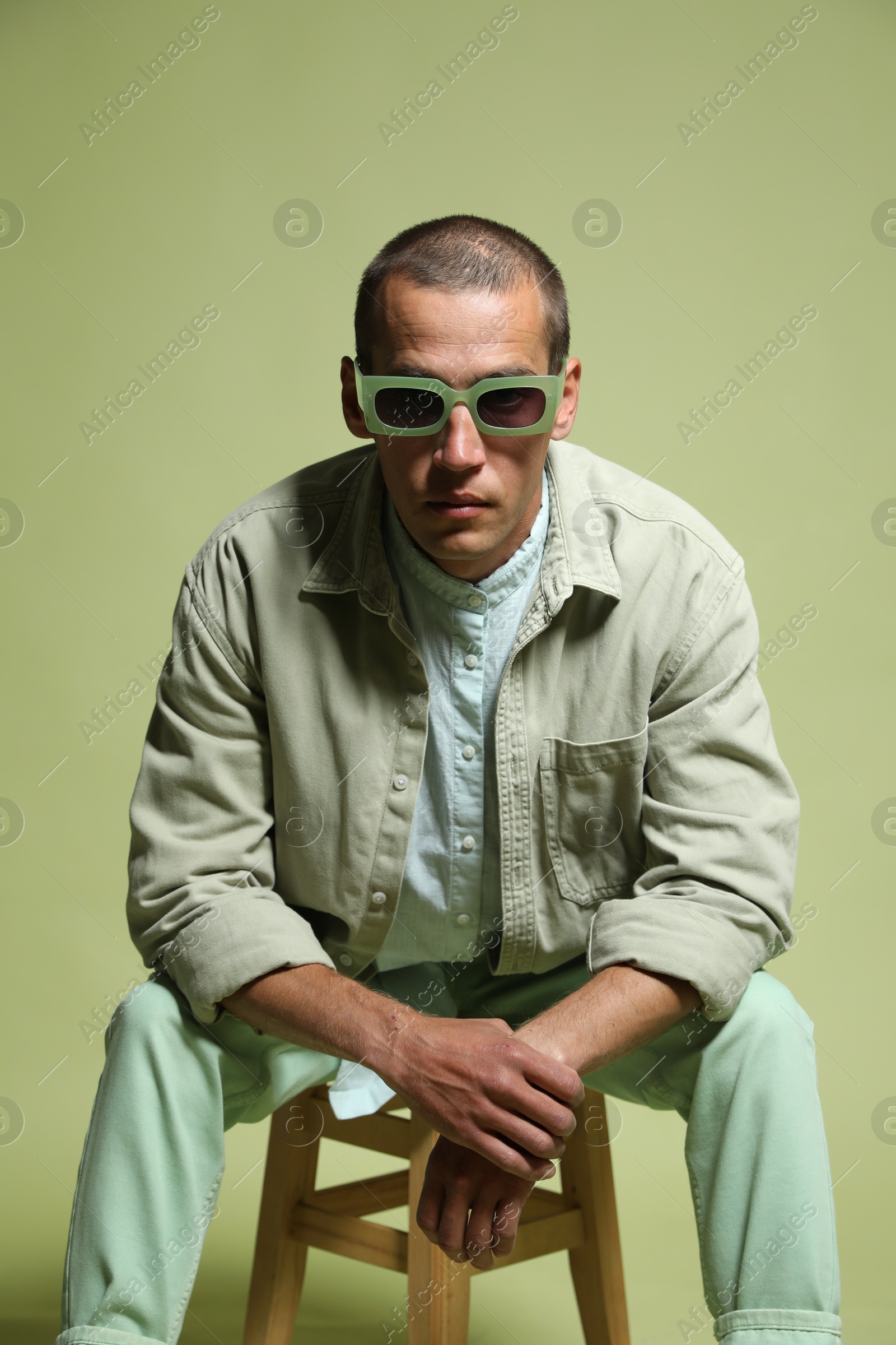 Fashionable portrait of handsome man in stylish outfit on green background Photo of Fashionable portrait of handsome man in stylish outfit on green background