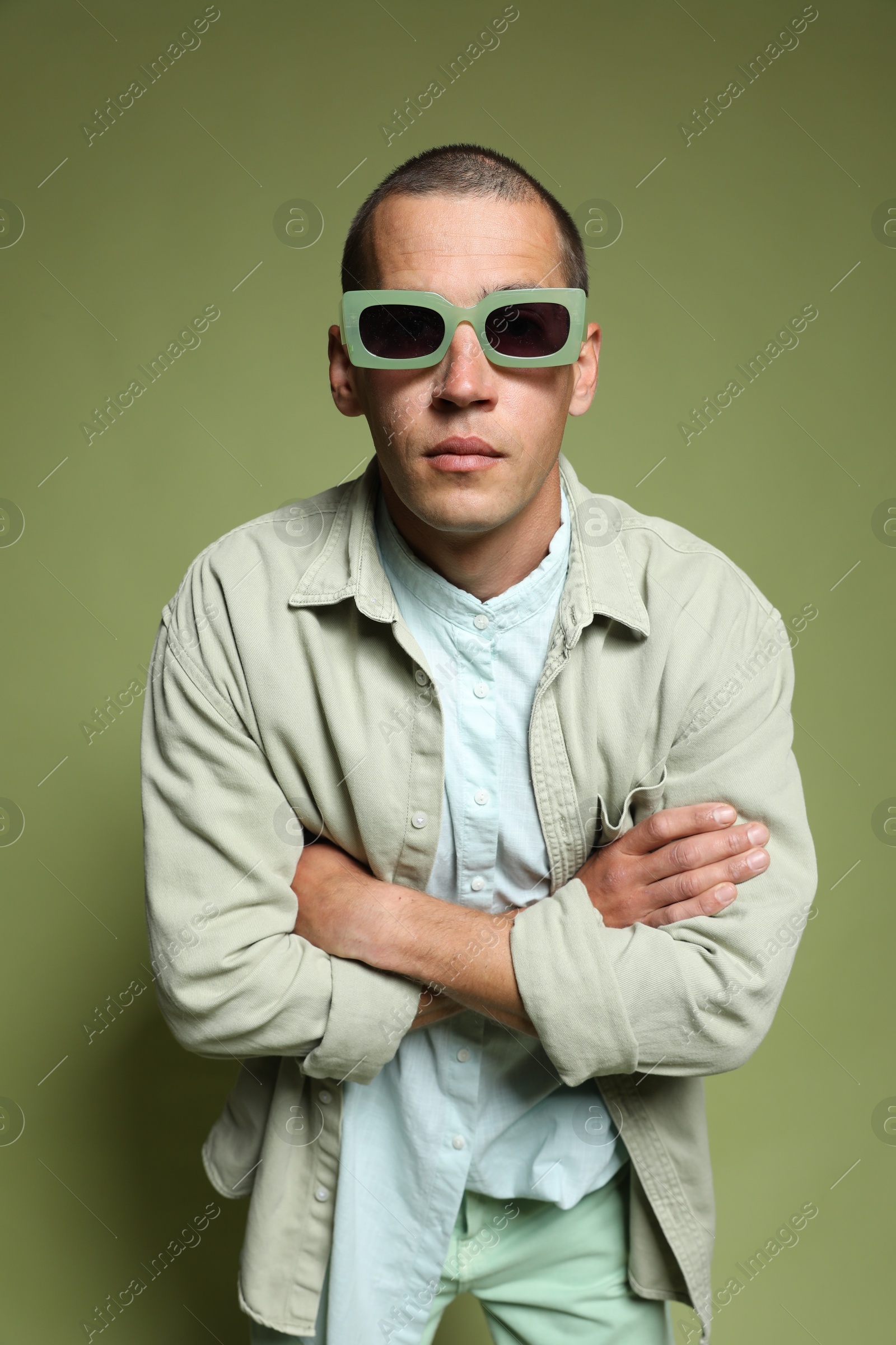 Fashionable portrait of handsome man in stylish outfit on green background Photo of Fashionable portrait of handsome man in stylish outfit on green background