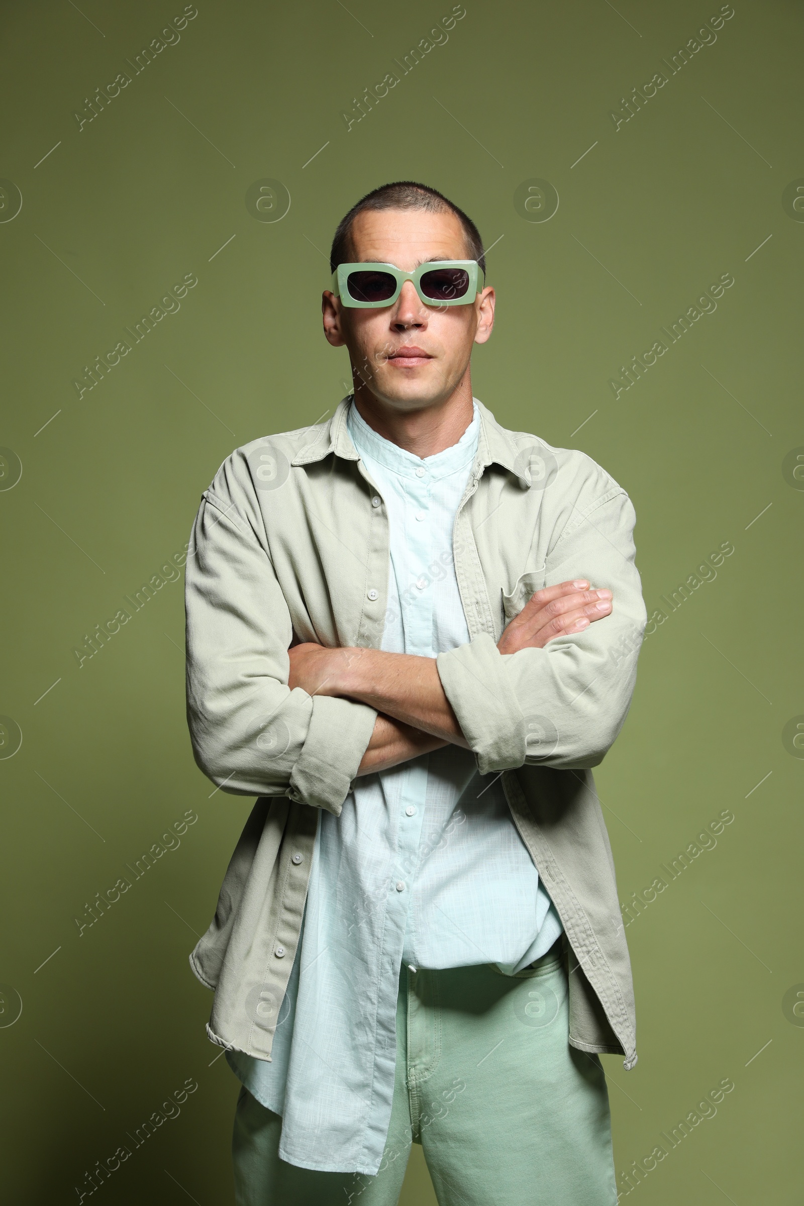 Fashionable portrait of handsome man in stylish outfit on green background Photo of Fashionable portrait of handsome man in stylish outfit on green background