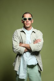 Photo of Fashionable portrait of handsome man in stylish outfit on green background
