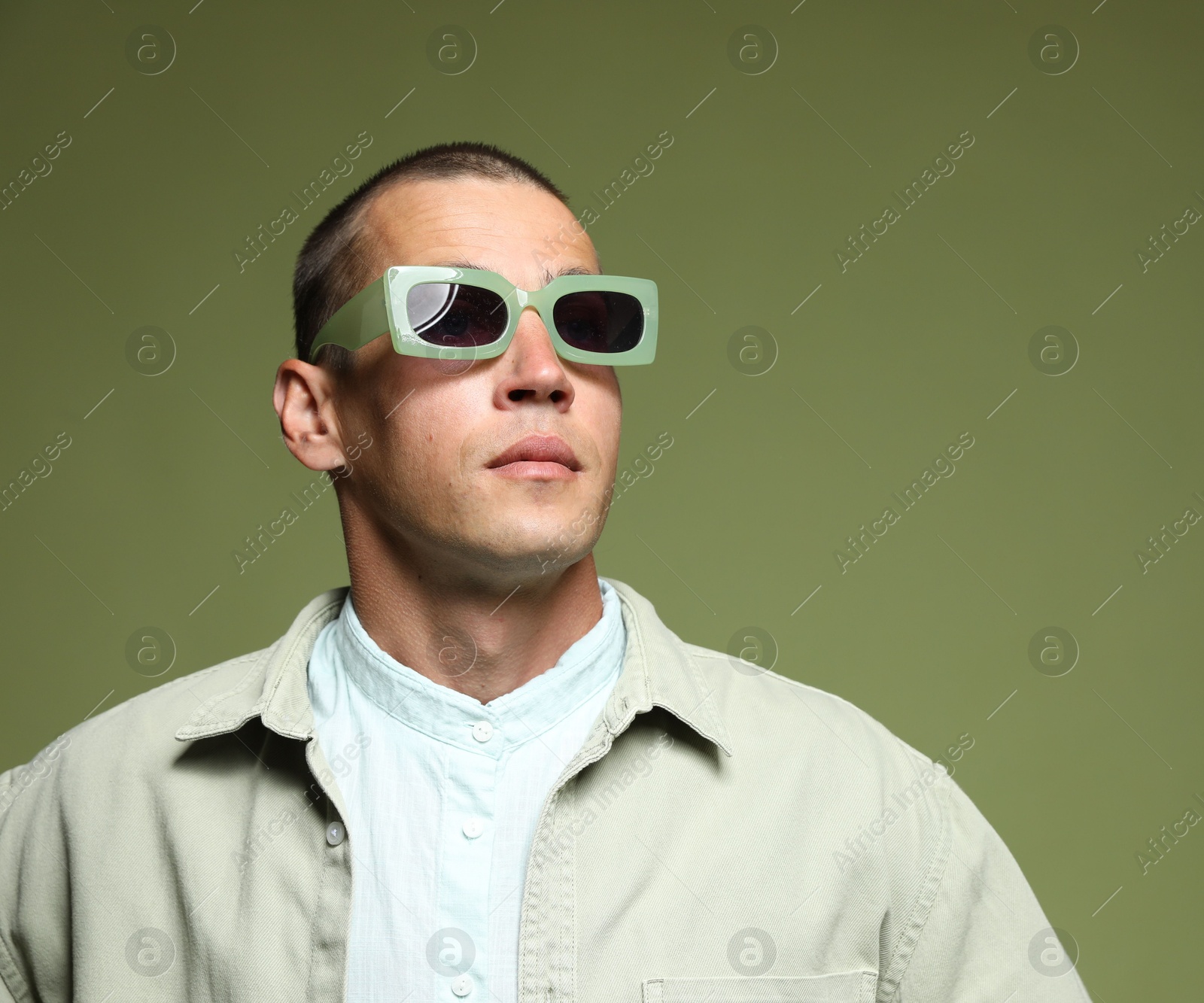 Fashionable portrait of handsome man in stylish outfit on green background Photo of Fashionable portrait of handsome man in stylish outfit on green background