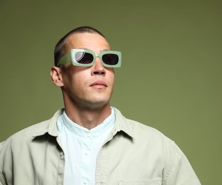 Photo of Fashionable portrait of handsome man in stylish outfit on green background