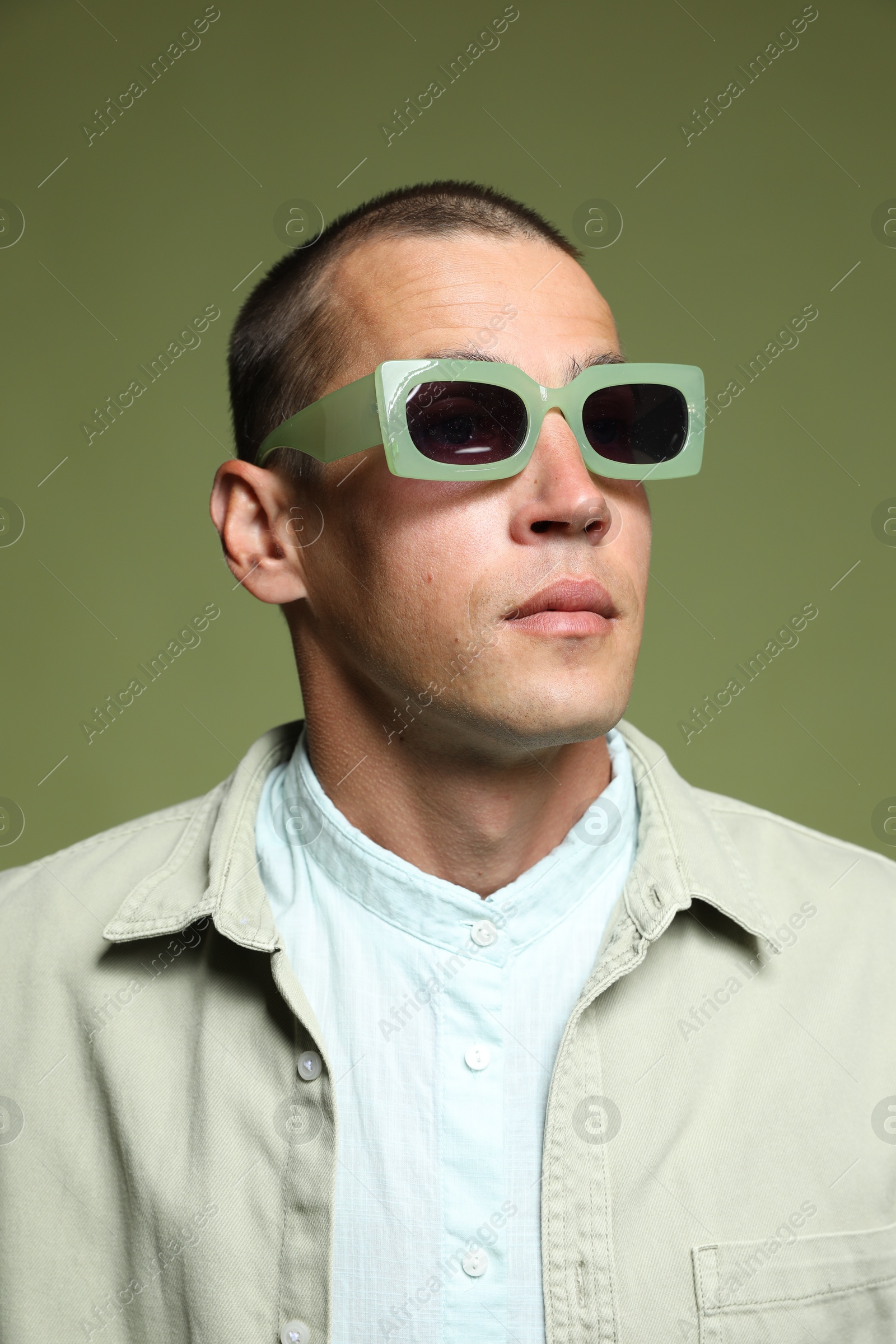 Fashionable portrait of handsome man in stylish outfit on green background Photo of Fashionable portrait of handsome man in stylish outfit on green background