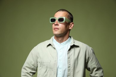 Photo of Fashionable portrait of handsome man in stylish outfit on green background