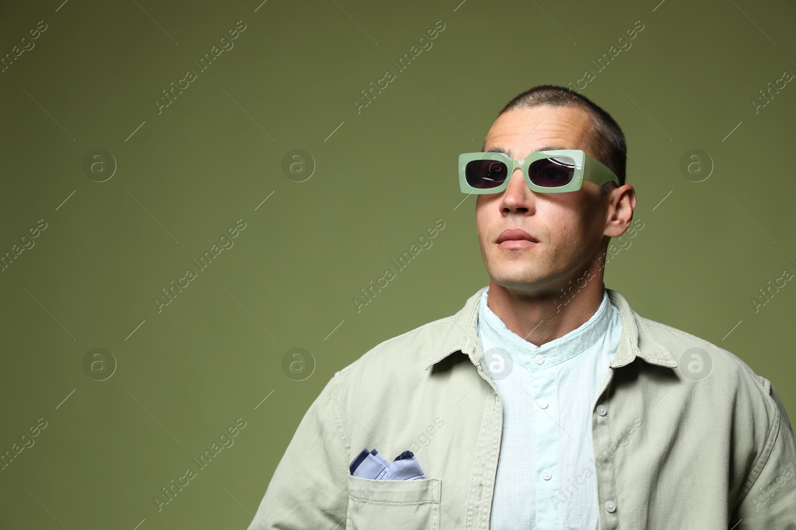 Fashionable portrait of handsome man in stylish outfit on green background, space for text Photo of Fashionable portrait of handsome man in stylish outfit on green background, space for text