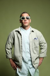 Photo of Fashionable portrait of handsome man in stylish outfit on green background