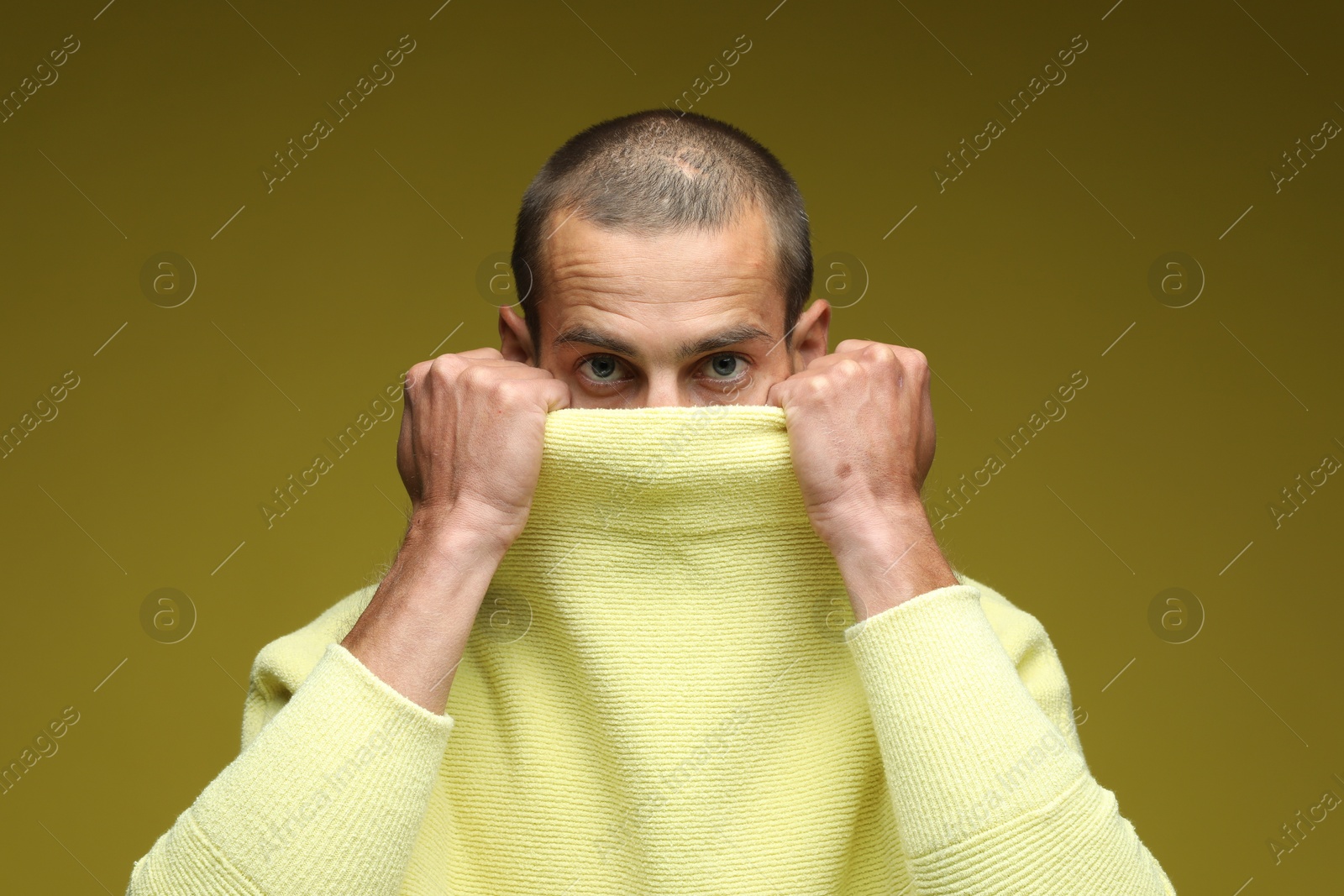 Fashionable portrait of handsome man in stylish outfit on olive background Photo of Fashionable portrait of handsome man in stylish outfit on olive background