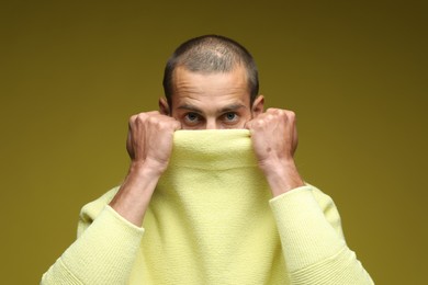 Photo of Fashionable portrait of handsome man in stylish outfit on olive background