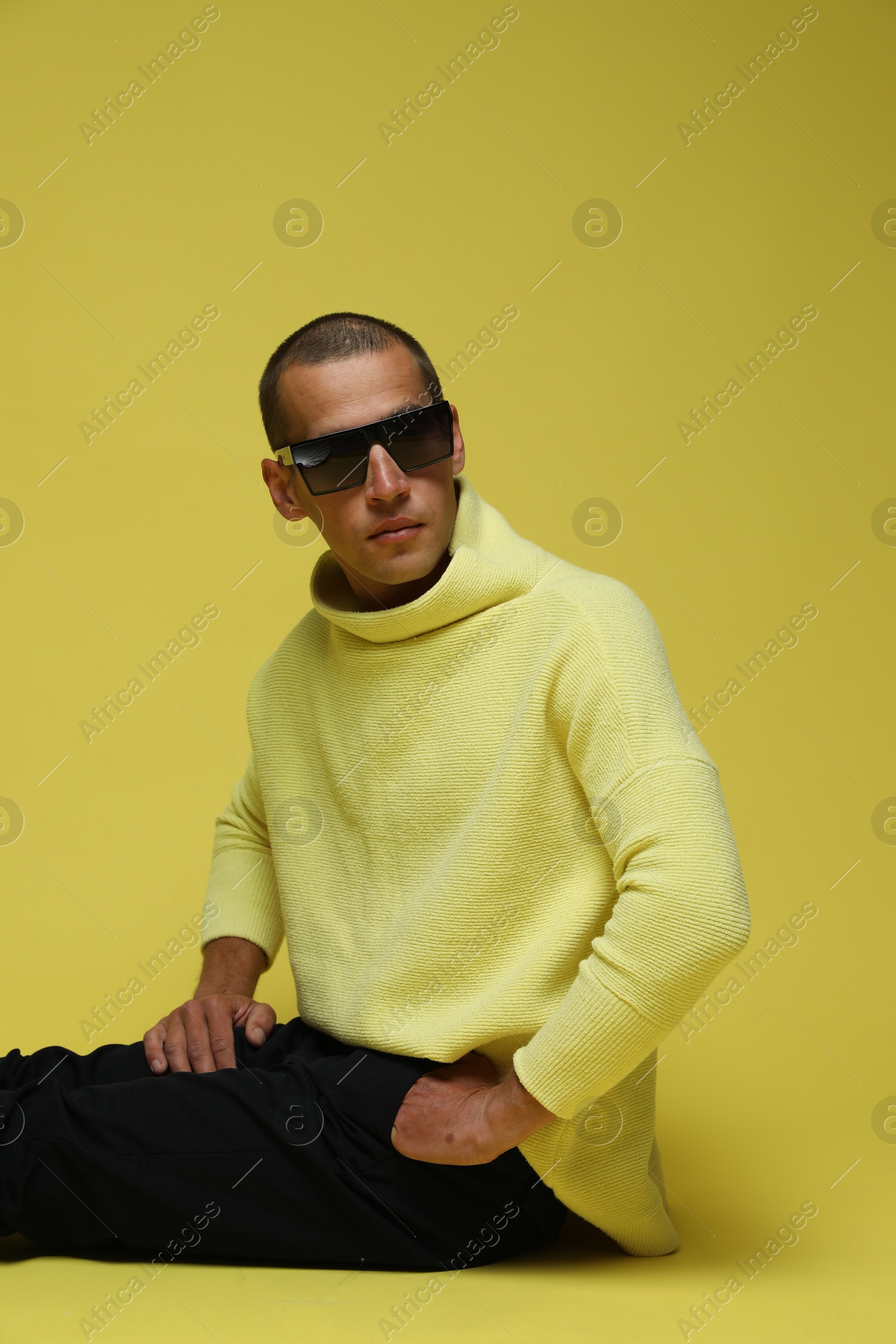 Fashionable portrait of handsome man in stylish outfit on yellow background Photo of Fashionable portrait of handsome man in stylish outfit on yellow background