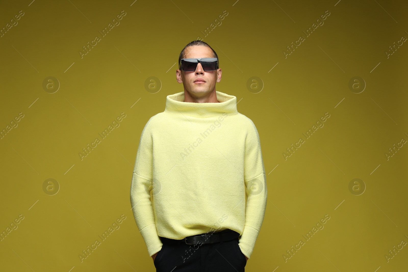 Fashionable portrait of handsome man in stylish outfit on olive background Photo of Fashionable portrait of handsome man in stylish outfit on olive background
