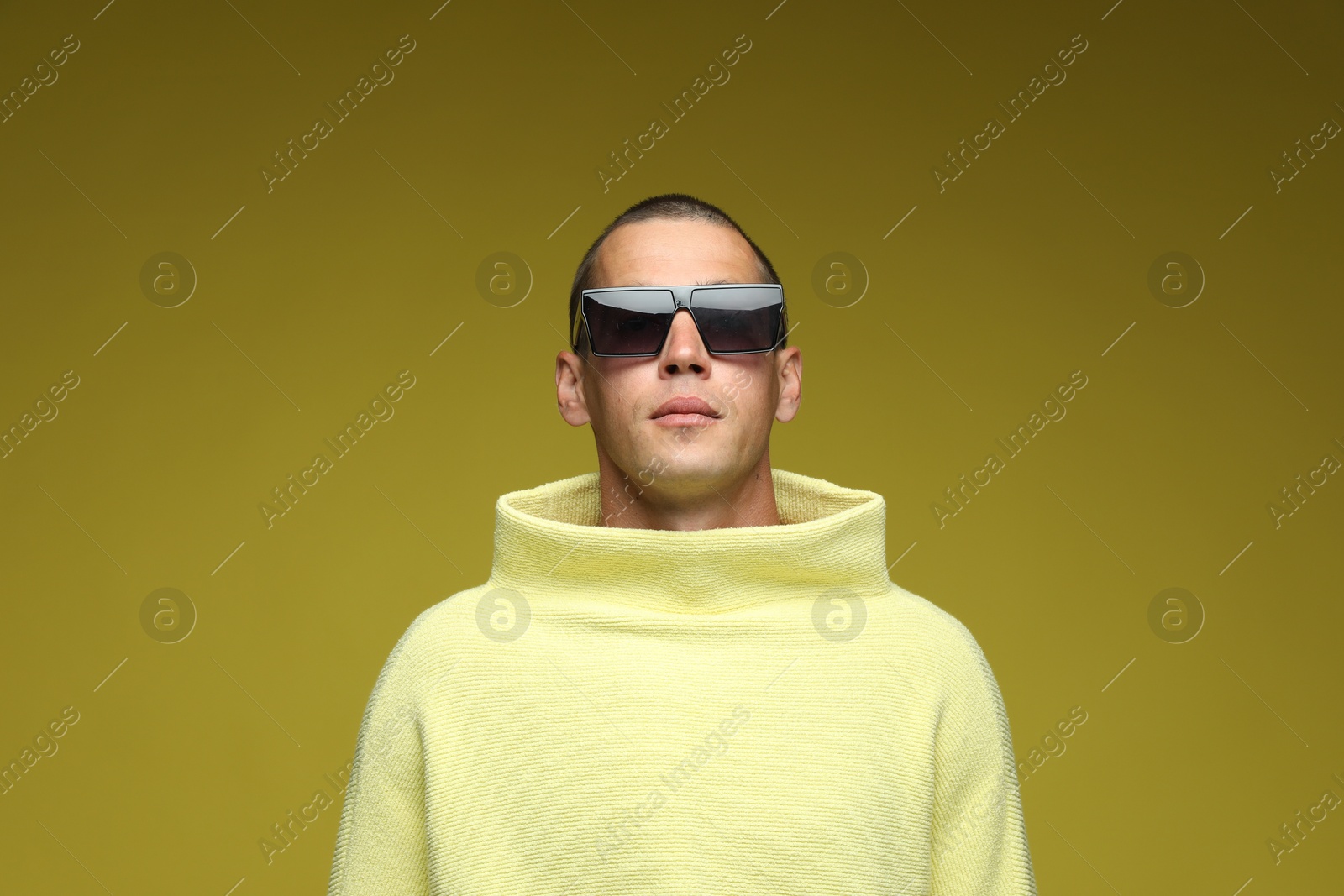 Fashionable portrait of handsome man in stylish outfit on olive background Photo of Fashionable portrait of handsome man in stylish outfit on olive background