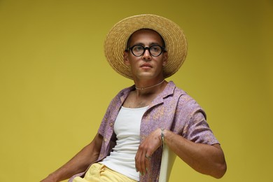 Photo of Fashionable portrait of handsome man in stylish outfit on yellow background
