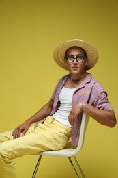 Photo of Fashionable portrait of handsome man in stylish outfit on yellow background