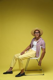 Photo of Fashionable portrait of handsome man in stylish outfit on yellow background