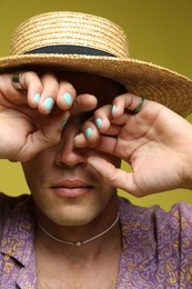 Photo of Fashionable portrait of handsome man in stylish outfit on olive background, closeup