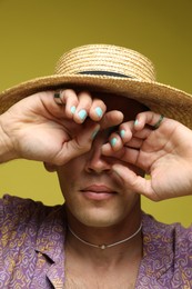 Photo of Fashionable portrait of handsome man in stylish outfit on olive background, closeup