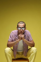 Photo of Fashionable portrait of handsome man in stylish outfit on color background