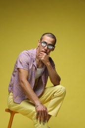 Photo of Fashionable portrait of handsome man in stylish outfit on color background