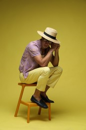 Photo of Fashionable portrait of handsome man in stylish outfit on color background
