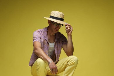 Photo of Fashionable portrait of handsome man in stylish outfit on color background