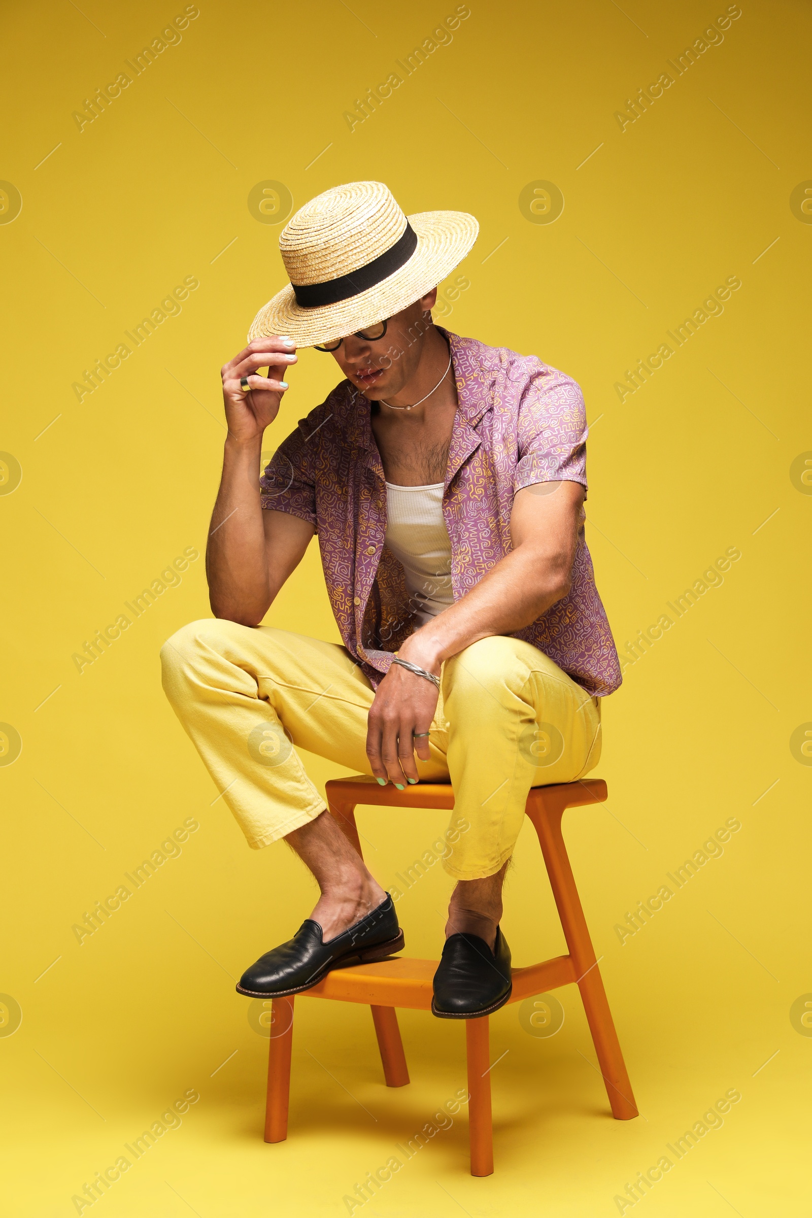 Fashionable portrait of handsome man in stylish outfit on yellow background Photo of Fashionable portrait of handsome man in stylish outfit on yellow background