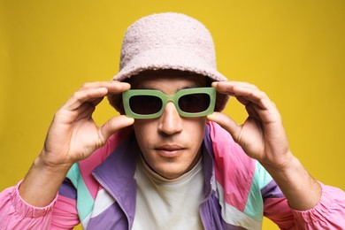 Photo of Fashionable portrait of handsome man in stylish outfit on yellow background