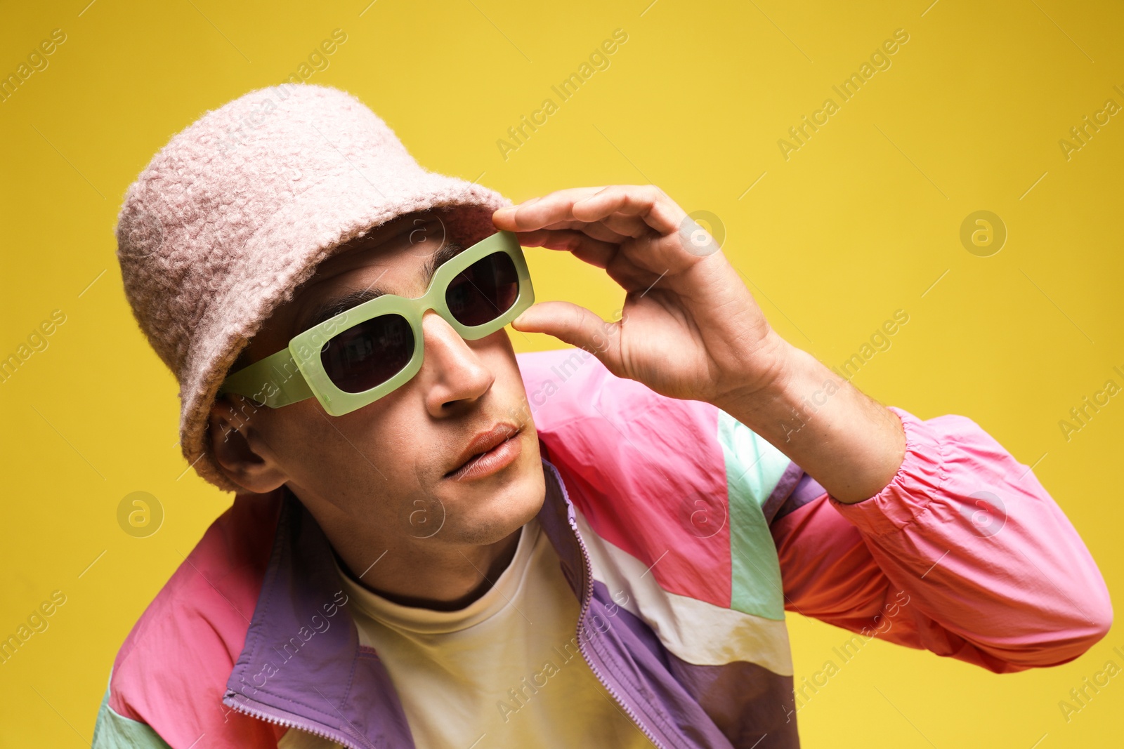 Fashionable portrait of handsome man in stylish outfit on yellow background Photo of Fashionable portrait of handsome man in stylish outfit on yellow background