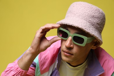Photo of Fashionable portrait of handsome man in stylish outfit on color background