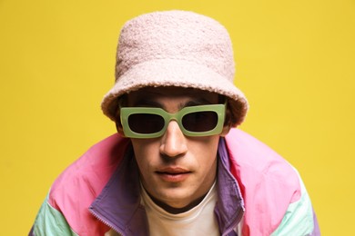 Photo of Fashionable portrait of handsome man in stylish outfit on yellow background