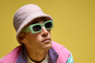 Photo of Fashionable portrait of handsome man in stylish outfit on color background, space for text