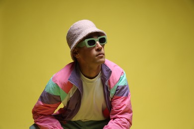 Photo of Fashionable portrait of handsome man in stylish outfit on color background, space for text