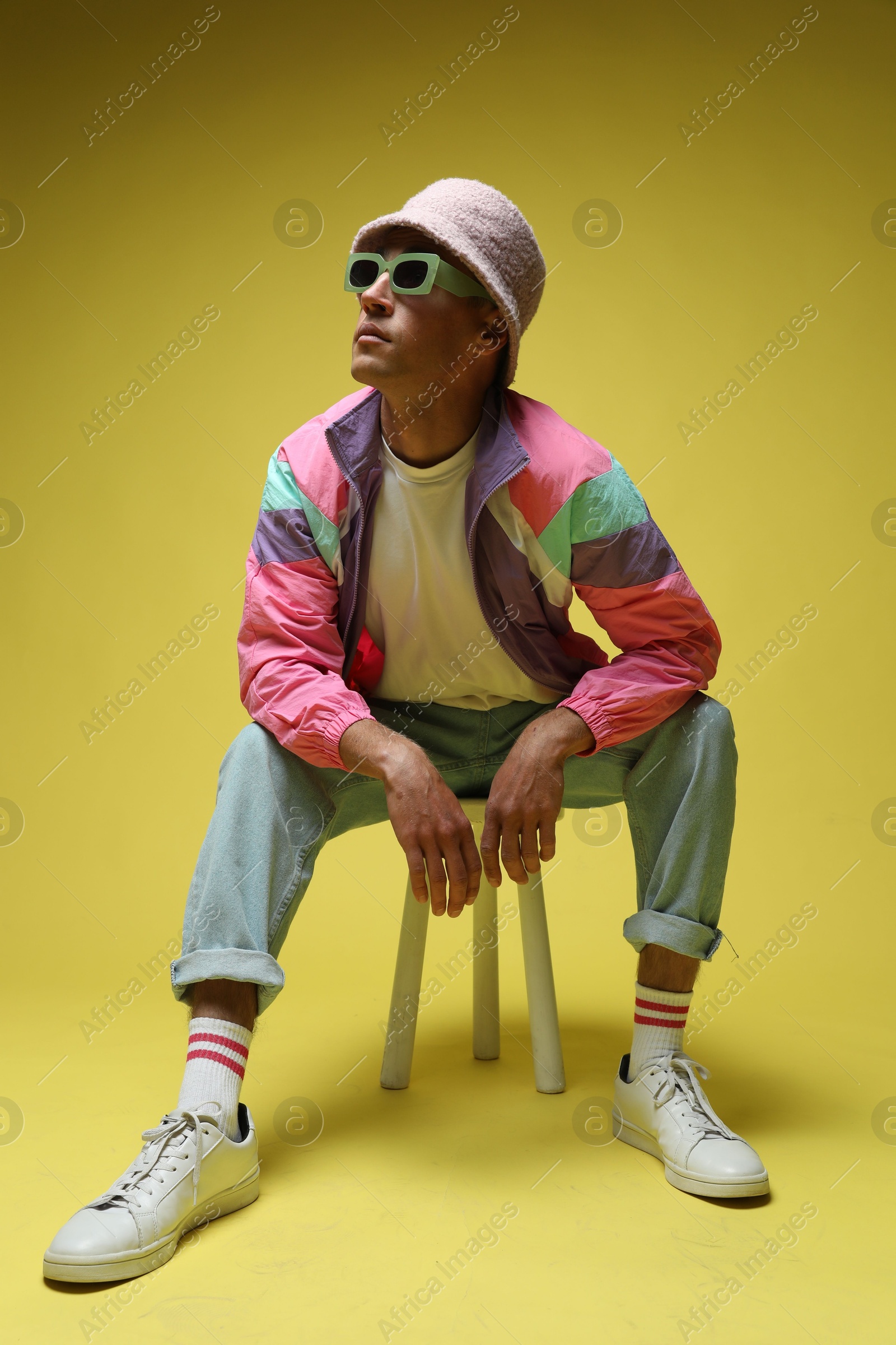 Fashionable portrait of handsome man in stylish outfit on yellow background Photo of Fashionable portrait of handsome man in stylish outfit on yellow background