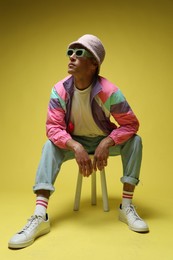 Photo of Fashionable portrait of handsome man in stylish outfit on yellow background
