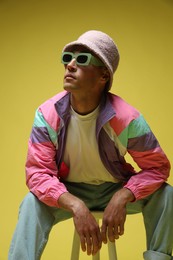 Photo of Fashionable portrait of handsome man in stylish outfit on yellow background