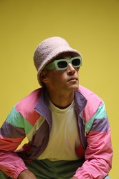 Photo of Fashionable portrait of handsome man in stylish outfit on yellow background