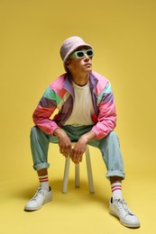 Photo of Fashionable portrait of handsome man in stylish outfit on yellow background