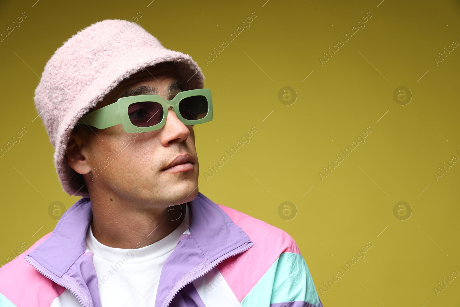 Fashionable portrait of handsome man in stylish outfit on olive background, space for text Photo of Fashionable portrait of handsome man in stylish outfit on olive background, space for text