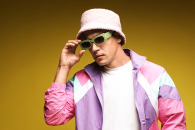 Photo of Fashionable portrait of handsome man in stylish outfit on yellow background