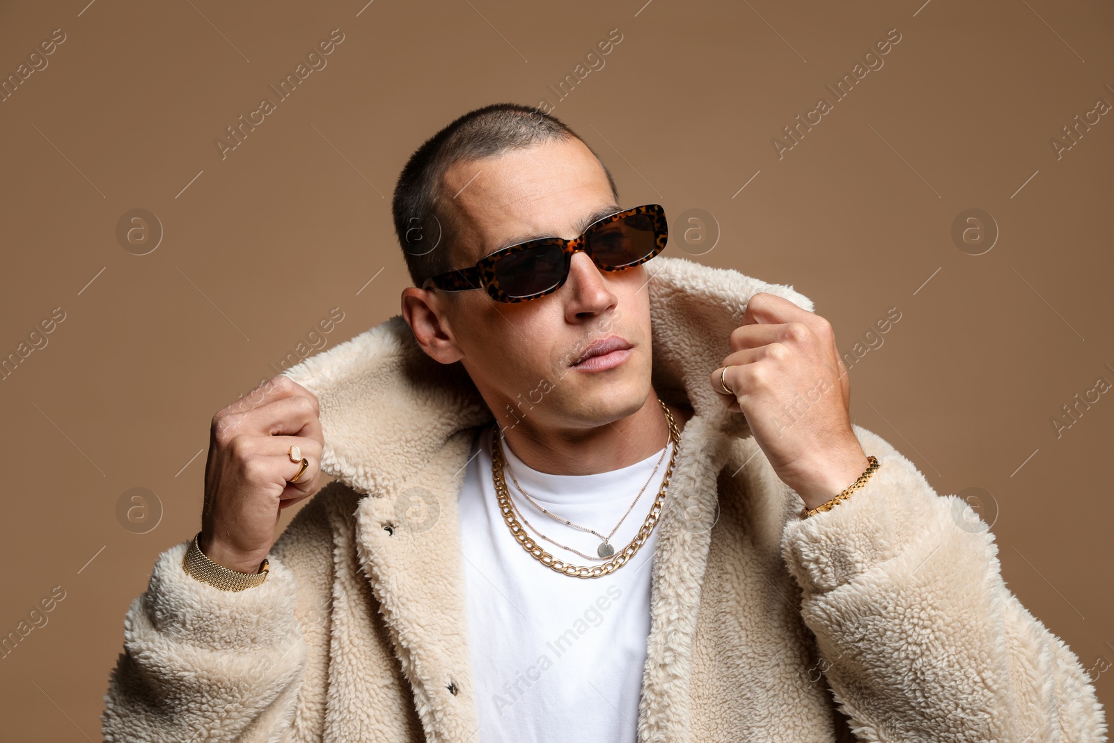 Fashionable portrait of handsome man in stylish outfit on brown background Photo of Fashionable portrait of handsome man in stylish outfit on brown background