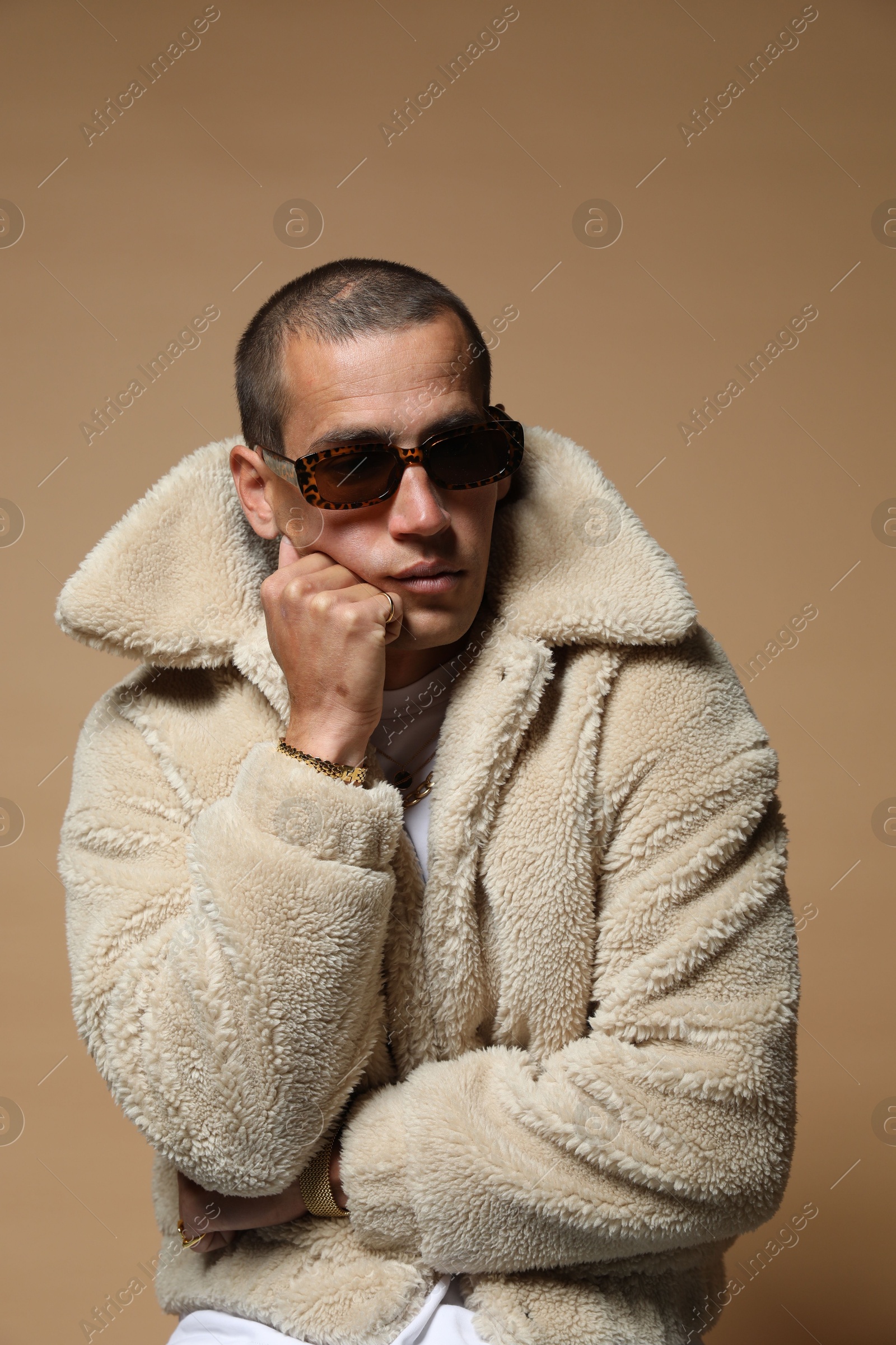 Fashionable portrait of handsome man in stylish outfit on brown background Photo of Fashionable portrait of handsome man in stylish outfit on brown background