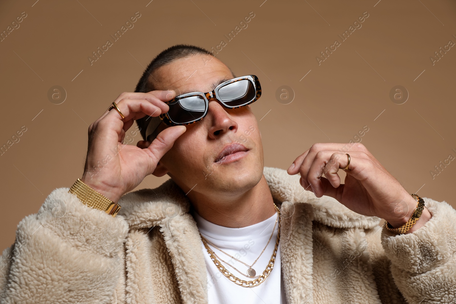 Fashionable portrait of handsome man in stylish outfit on brown background Photo of Fashionable portrait of handsome man in stylish outfit on brown background